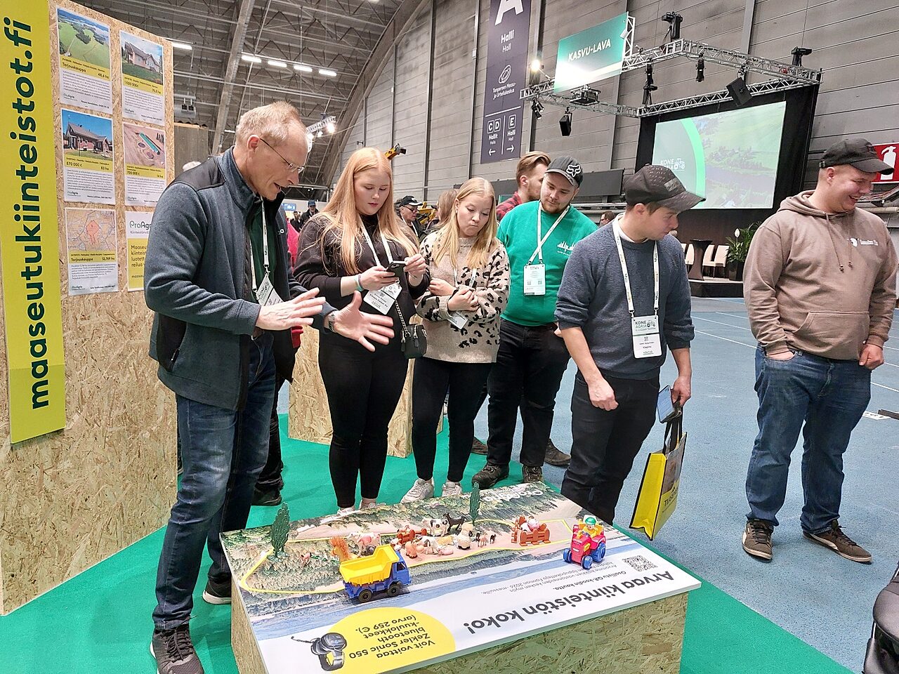 Ihmisia juttelemassa matalan kilpailupoydan aarella